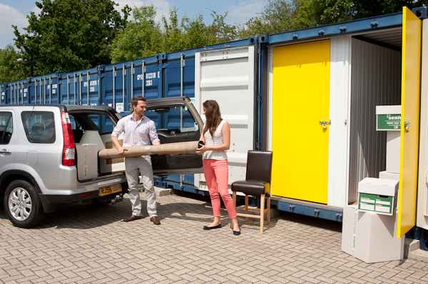 Image of a couple moving their items into a blue storage unit.